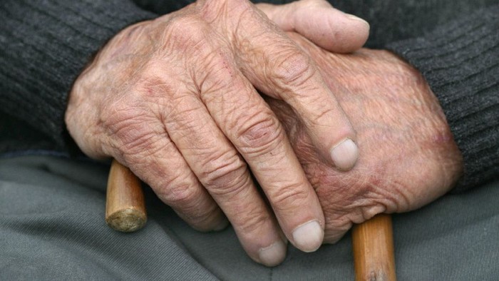 Alte Hände halten Gehstock