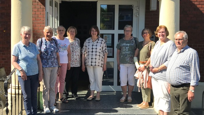 Gruppe von Menschen, die vor einem Gebäude steht.