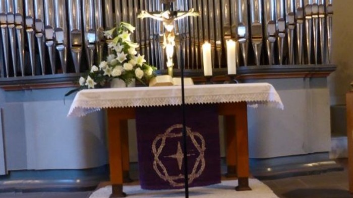 Altar in Kirche mit Kerzen und Blumen