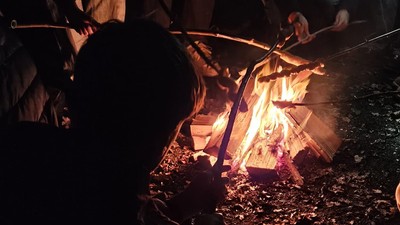 Kinder / Jugendliche um ein Lagerfeuer mit Stockbrot