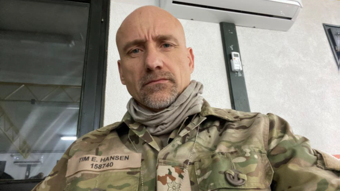 Mand i militæruniform med skjorte om halsen.