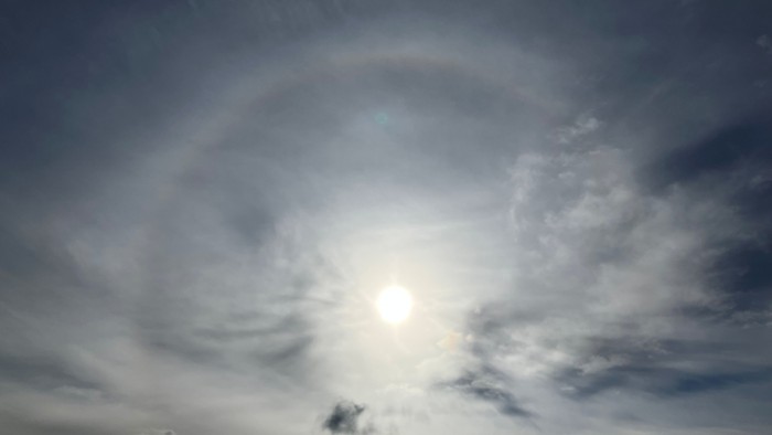 Lyst solskin, der skinner gennem en overskyet himmel med en svag glorie.