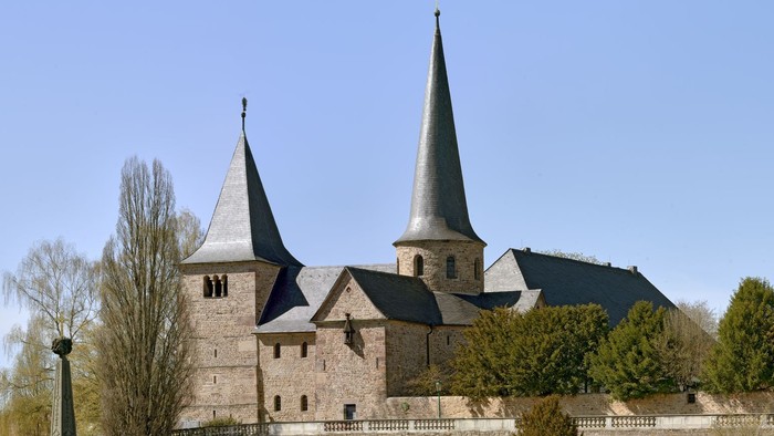 Historische Steinburg mit Zwillingstürmen und befestigten Mauern in einem gestalteten Innenhof.