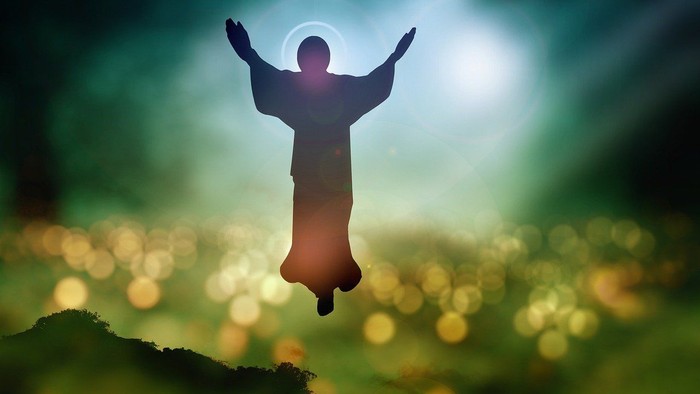 En skikkelse med udstrakt arme flyver over et blømt landskab.