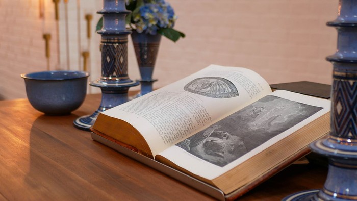 Bibel med stort træsnit tryk på alter lavet af mørkt træ i udlejre kirke. 