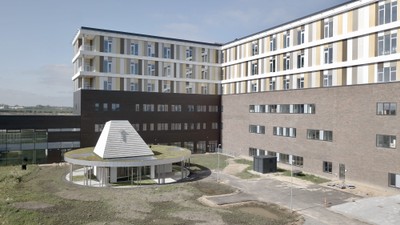 Det er et moderne boligkompleks med flere bygninger og en central plads.