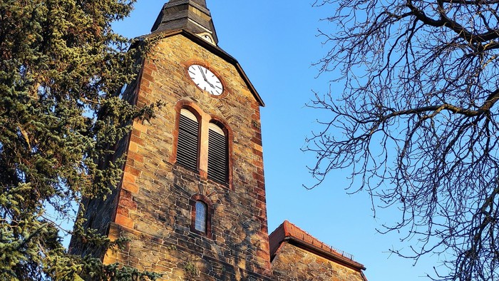 Gotische Kirche mit hohem Turm und Uhr.