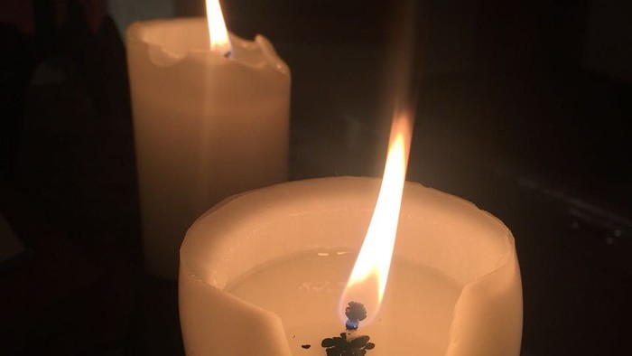 Zwei brennende Kerzen in dunkler Umgebung