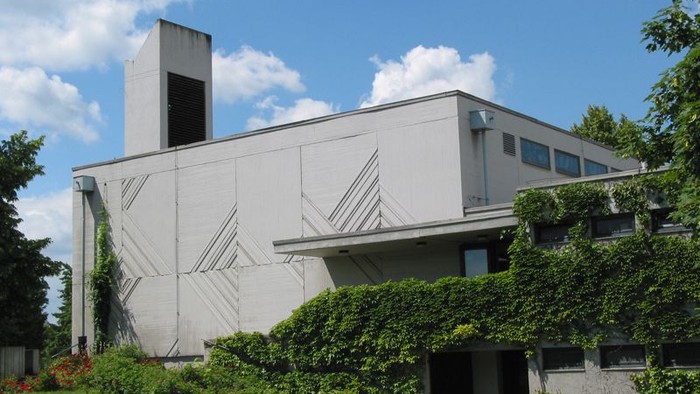 Modernes Gebäude mit flachem Dach und grünem Rasen davor