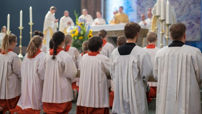 Eine Gruppe von Menschen in weißen Gewändern nimmt an einer religiösen Zeremonie teil.