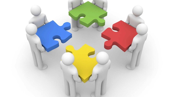 Fire figurer holder stykker af et puzzle sammen.