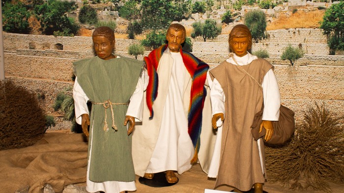 Szene einer Statue, die Jesus Christus mit zwei Jüngern in antiker biblischer Kleidung darstellt.