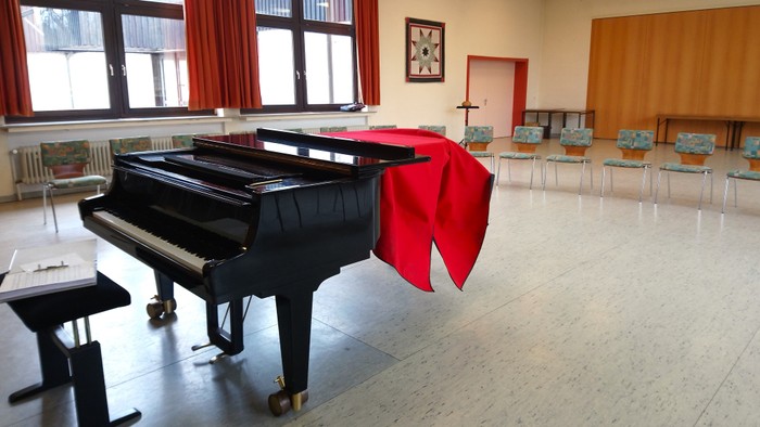 In einem hellen Raum des Gemeindehauses Bad Driburg steht ein glänzender Flügel.