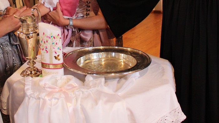 Ein Priester segnet ein Baby in einer Kirche