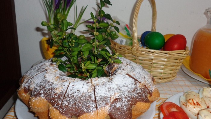 Der Kuchen ist mit Puderzucker bestäubt und mit einer grünen Pflanze dekoriert.