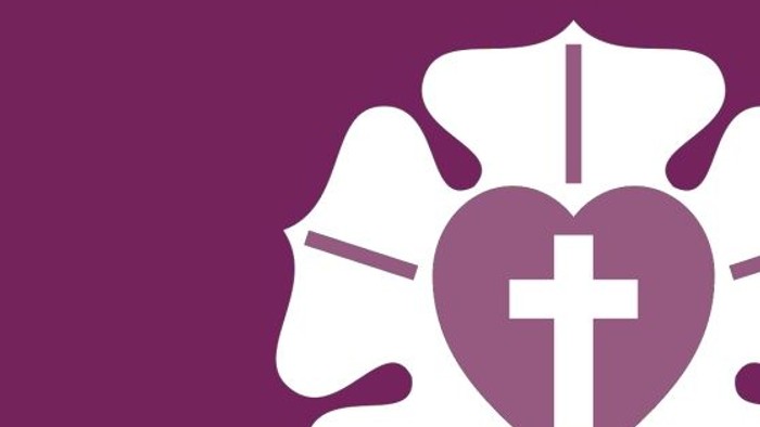 Herz mit Kreuz in Lilienform auf lila Hintergrund