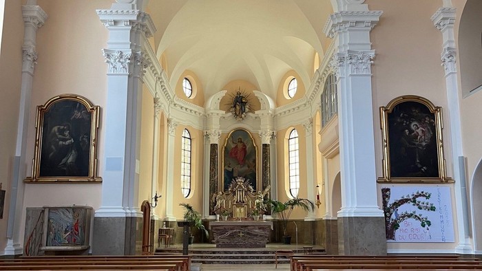 Innenraum einer Kirche mit Holzstühlen und Altären