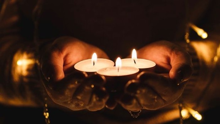 Hænder holder en lygte med tre tænder.