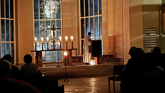 Eine Hochzeitszeremonie in einer Kirche mit einem Paar vorne und Gästen hinten