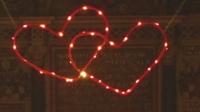 Zwei leuchtende Herzdekorationen vor einem dunklen Hintergrund