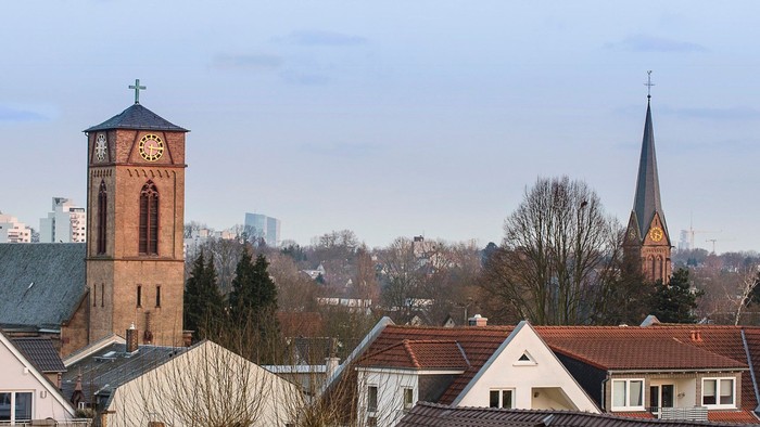 Zwei Kirchen mit hohen Türmen in einem Wohngebiet