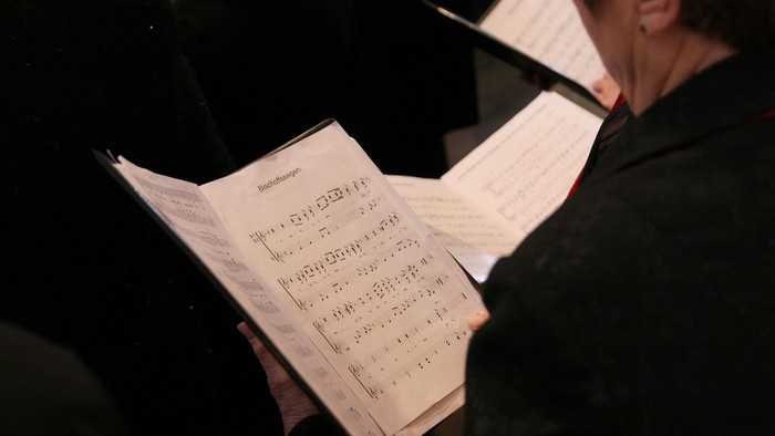 Person hält Notenblatt in den Händen