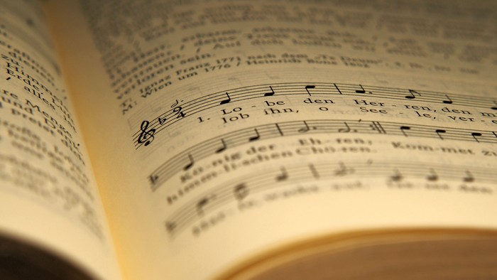 Kirchengesangbuch, das aufgeschlagen ist. Ein paar Noten und die Worte 