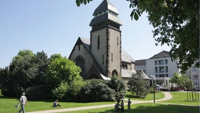 Kirchengelände mit Menschen auf dem Rasen