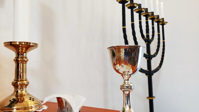 En rød bord med hvid duk og forskellige smykker og lysstaker