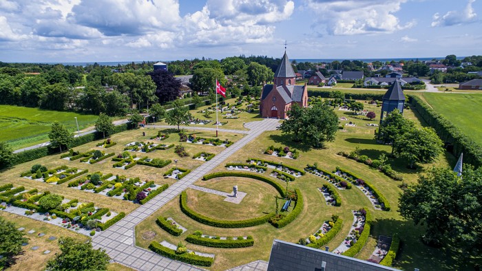 En smuk have med rounder og en røde bygning i midten