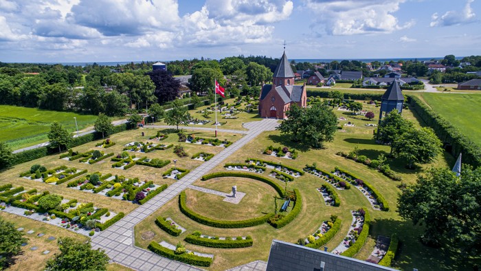 En smuk have med rounder og en røde bygning i midten