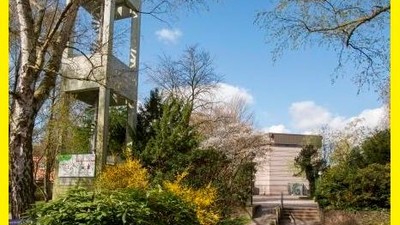 Ein Garten mit Treppe und Baum, umgeben von grünem Blattwerk und blühenden Büschen