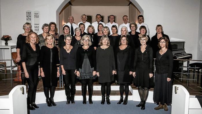 En gruppe korister poser i en kirke