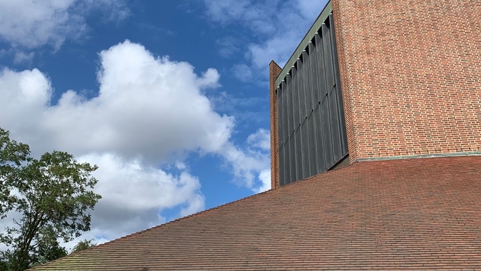 Rød murstensbygning med blå himmel og hvidt skyer