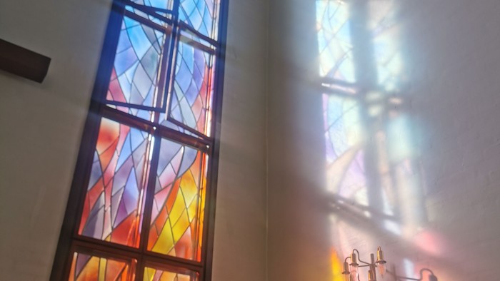 Stained glass vindue i kirke med farverne blå, rød og guld