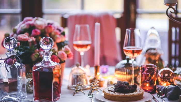 Eleganter Tisch mit Wein, Blumen und Dessert