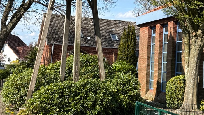 Moderner Holzturm zur Aussicht, umgeben von Grünflächen in einem Wohngebiet.