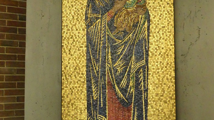 Mosaikikone der Jungfrau Maria mit dem Jesuskind und Engeln, darunter ein kerzenbeleuchteter Schrein.