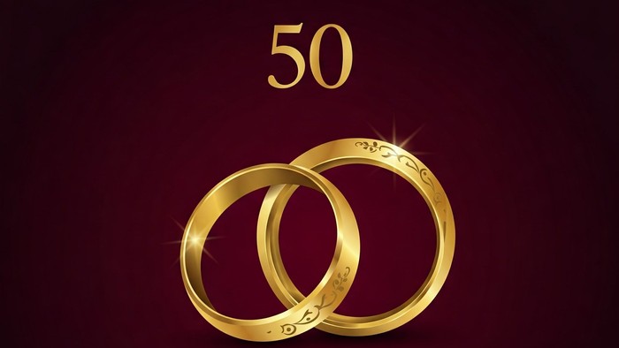 Goldene Eheringe vor dunklem Hintergrund mit der Zahl 50
