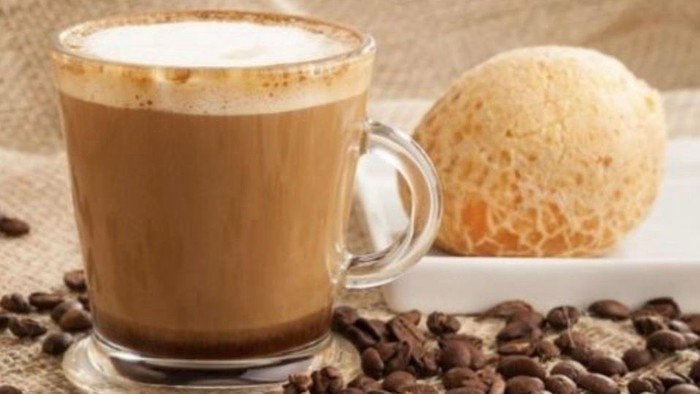 Glas-Kaffekop med kaffe med mælk, damp, iskugle på tallerken, kaffebønner i forgrunden 