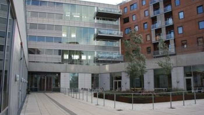 Et moderne bygningskompleks med glasfacader og indendørs have.