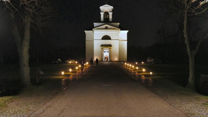En belyset vej leder til en lille kirke i natten