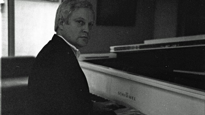 Ein Mann spielt Klavier in einem Raum.