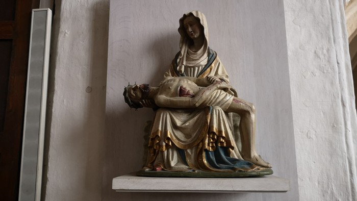 Die Statue zeigt eine sitzende Frau mit Kind auf dem Schoß.