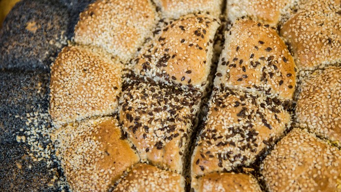 Nærbillede af en tekstureret overflade med pletter af mørk, plettet skimmelsvamp på et ru, muligvis organisk materiale.