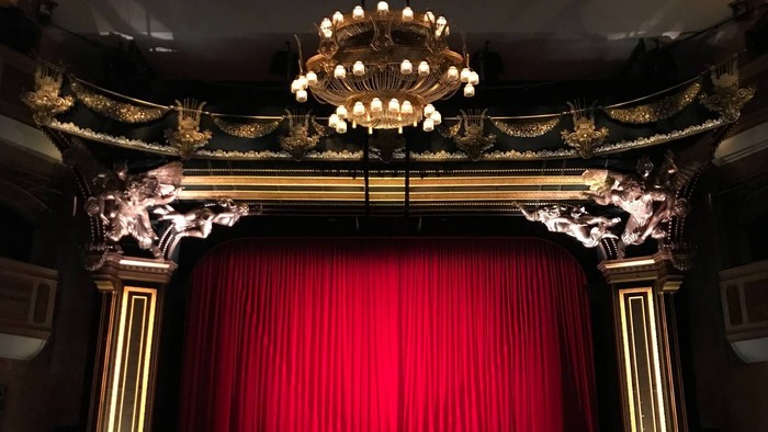 Prächtiger Theatervorhang mit goldener Dekoration und Kronleuchter