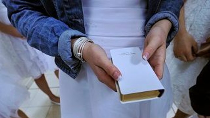 En person holder en hvid bog, mens en anden person trækker den.