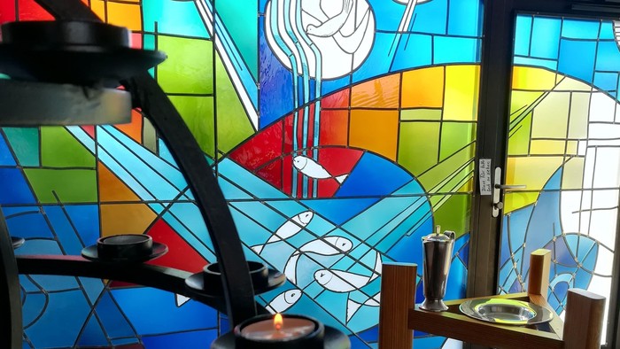 Bunte Kirchenfenster mit Kerzen und Tisch