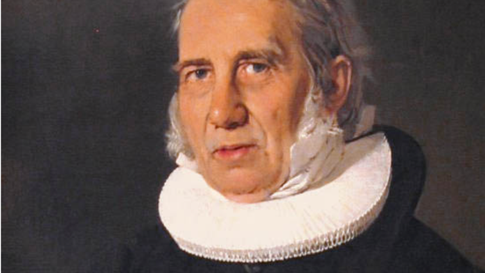 Portræt af en ældre mand i formelt tøj med en dekorativ krave og medalje.