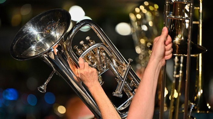 Zwei Hände halten und spielen Blechblasinstrumente